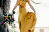 a marigold A-line wedding dress with a tied up bodice, a front slit and a short train for a non-traditional bride