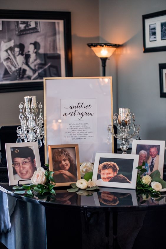 a memorial table with framed photos, candles and a sign is a cool idea for a wedding, honor everyone who is gone