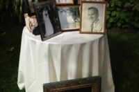 a memorial table with photos of the people who are gone and a chalkboard sign in a frame is a smart idea to rock