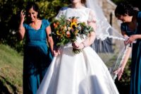 a modern wedding ballgown with a plain bodice and skirt, lace short sleeves and a lace veil