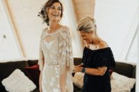 a nude wedding gown with white lace appliques and embroidery, with a catchy neckline and bell sleeves