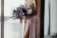 a pink silk slip wedding dress with pompoms, a thigh high slit and a deep neckline worn by Malin Akerman