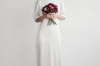 a plain white silk wedding dress with short sleeves and a high neckline plus red heels for an accent
