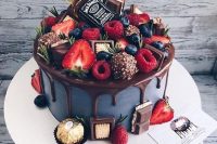 a pretty and cool groom’s cake in grey, with chocolate drip, chocolate candies, berries, herbs and a real mini alcohol bottle is amazing