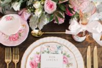 a refined and romantic sprign bridal shower tablescape with floral plates and teaware, pink blooms and gold touches