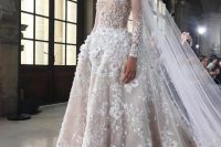 a romantic wedding ballgown with elegant illusion sleeves, a high neckline and a pleated full skirt with a train and 3D floral appliques all over