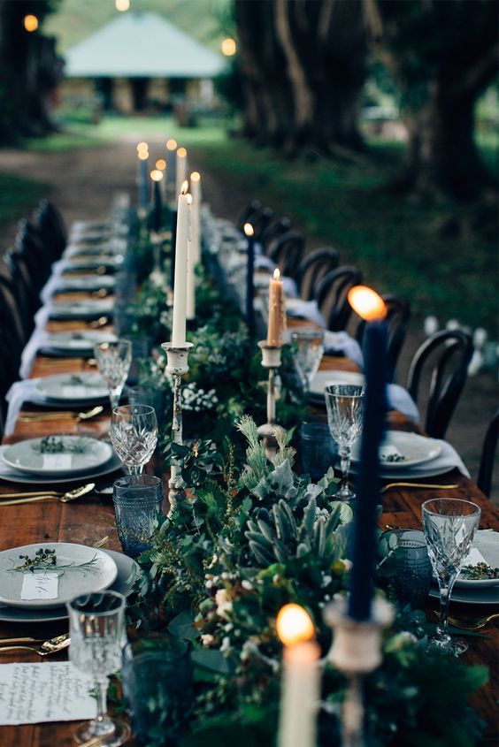 a textural greenery table runner with lots of various herbs and foliage and candles