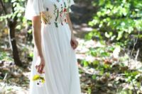 a unique A-line wedding dress with bright embroidery, short sleeves, a high neckline and a pleated skirt