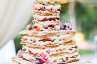a waffle wedding cake with creamy filling, lots of berries and fresh blooms for a rustic brunch wedding