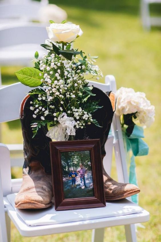 a wedding chair with blooms, cowboy boots and a family photo to remember those who you love but they are gone