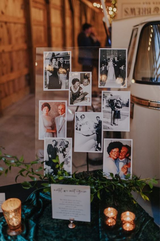 a wedding memorial display with the photos of the people who are missing in acryl, with greenery and candles around