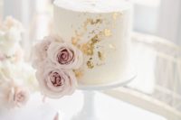 a white bridal shower cake with gold leaf and blush blooms looks very chic and stylish