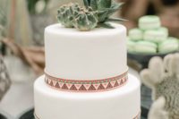 a white wedding cake with bright patterns, cacti and succulents for a boho desert wedding