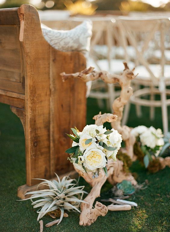 decorate the aisle with driftwood, air plants, white blooms and greenery to make it chic and beachy