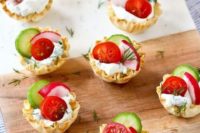 pastry cups with delicious dip, cucumbers, tomatoes and radishes plus herbs for spring