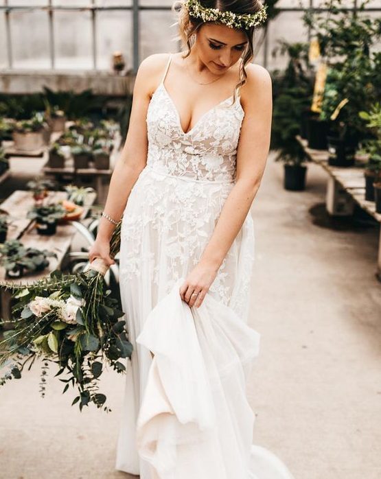 a beautiful floral lace A-line wedding dress with spaghetti straps, a deep V-neckline and a train
