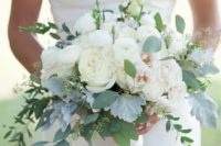 a beautiful wedding bouquet composed of white blooms and pale greenery for a refined look