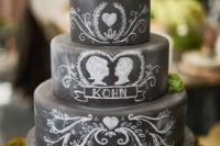 a black chalkboard wedding cake with chalking, with a succulent and some moss on top is a lovely idea for a modern wedding