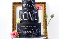 a black chalkboard wedding cake with chalking, with bright and neutral blooms on top is a fantastic idea for a modern wedding