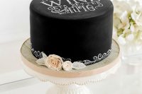 a black chalkboard wedding cake with chalking, with white and blush blooms is a lovely idea for a modern wedding