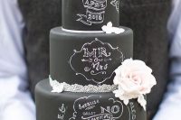 a black chalkboard wedding cake with lace ribbon, white and blush blooms and chalking right on the cake is a fantastic idea to rock