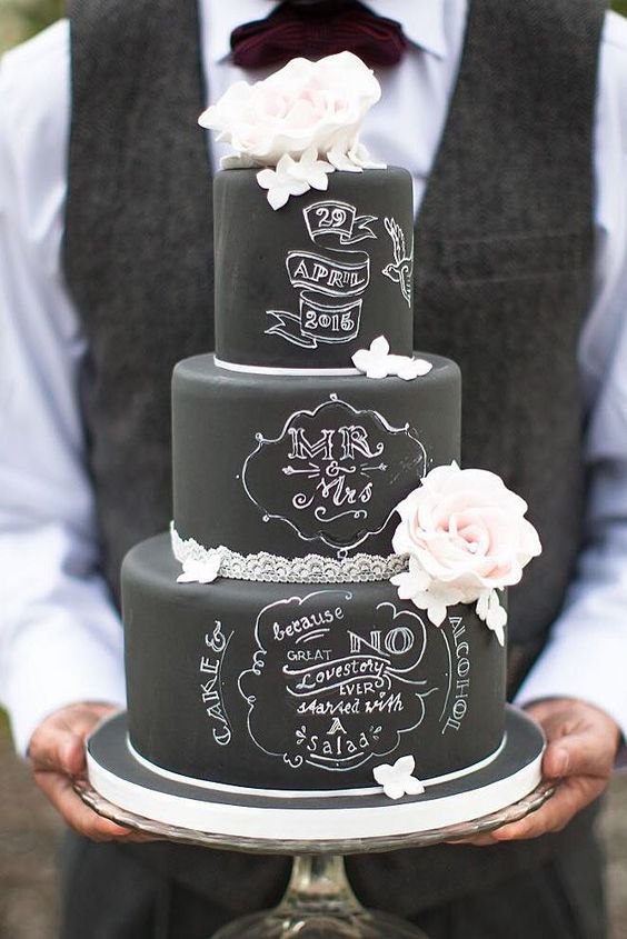 a black chalkboard wedding cake with lace ribbon, white and blush blooms and chalking right on the cake is a fantastic idea to rock