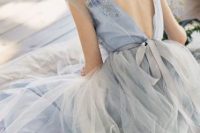 a blue A-line wedding dress with embellishments and embroidery, a low back and a layered skirt is a beautiful idea to rock