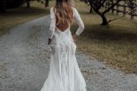 a boho lace A-line wedding dress with long sleeves and a train, a low back is a very chic and cool idea