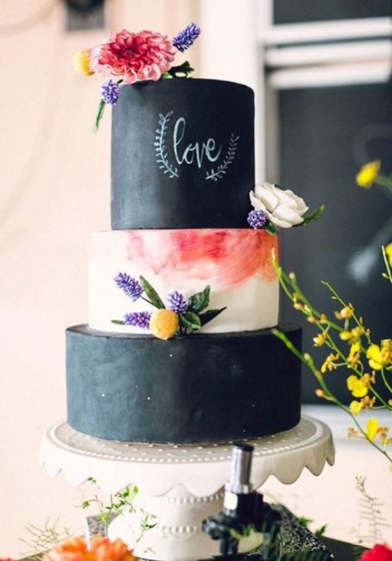 a bold and cool wedding cake with chalkboard and a marble tier, with chalking, with bright and neutral blooms is a chic idea for a summer wedding