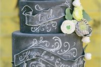 a bold chalkboard wedding cake with chalking, with chalked ribbon, neutral and bold blooms and paper blooms is a lovely solution