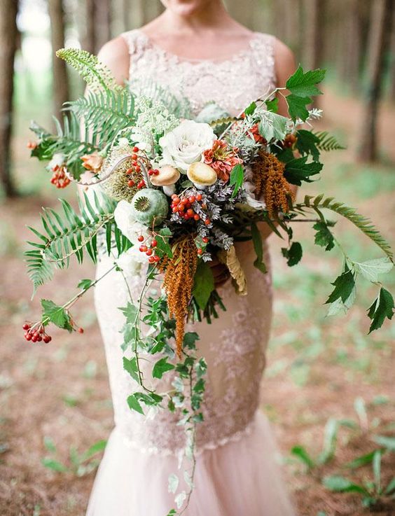 a bold fall woodland wedding bouquet of greenery, berries, white blooms, pale greenery and grasses plus real mushrooms