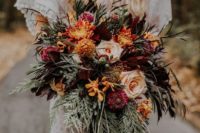 a bright wedding bouquet of orange, burgundy, pink and rust blooms, greenery and cascading elements