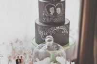 a chalkboard wedding cake with chalking and a pink bloom on top is a gorgeous idea for a modern wedding