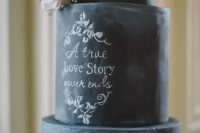 a chalkboard wedding cake with delicate chalking for a romantic touch and some white blooms on the cake is a gorgeous idea