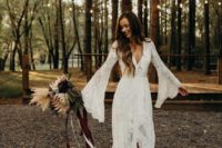 a chic boho lace wedding dress with a deep V-neckline, bell sleeves and a train for a boho woodland bride