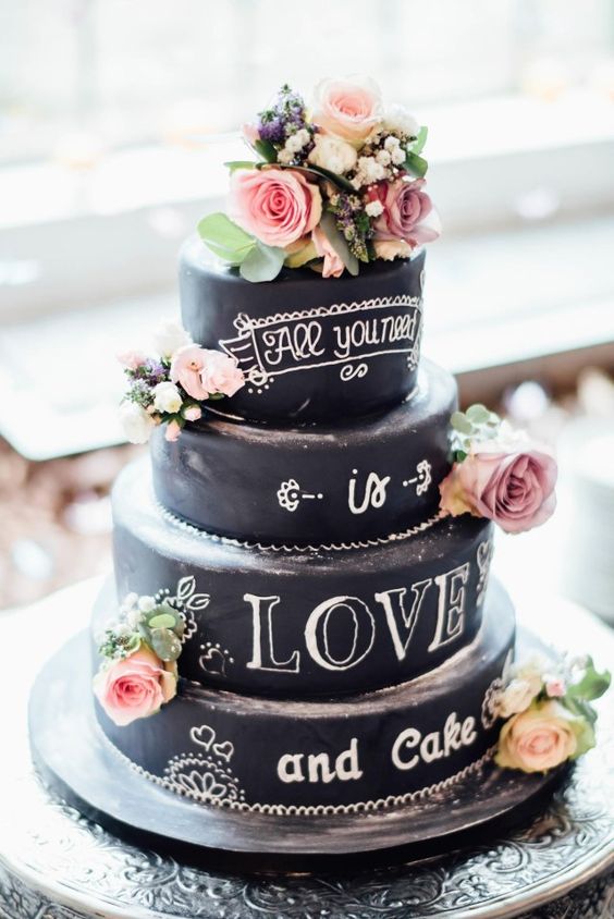 a chic chalkboard wedding cake with chalking, with pink and white blooms and some greenery is a very stylish idea to rock