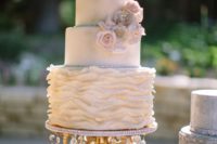 a chic neutral wedding cake with a textural tier and blush sugar blooms on a refined and chic stand