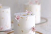 a delicious and sophisticated white individual wedding cake with gold leaf and blush blooms is fantastic