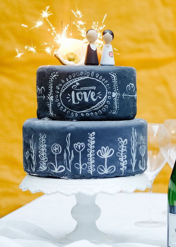 a festive chalkboard wedding cake with chalking and fun kokeshi toppers plus a bit of light is pure fun, it's super cool