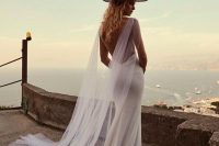 a fully embellished mermaid wedding dress with a low back, a small train and a tulel capelet plus a hat for a slight boho feel
