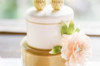 a glam gold and white wedding cake with a pink bloom and funny pineapple toppers is a lovely and cool idea