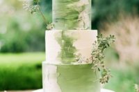 a gorgeous green and white wedding cake with brushstrokes and fresh greenery decor for a spring wedding