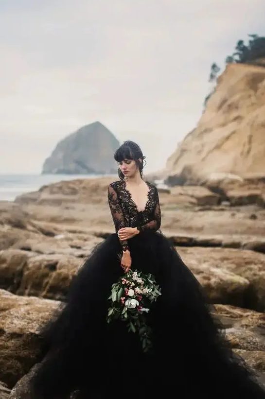 a gorgeous wedding dress with a black lace bodice with a deep V-neck and long sleeves and a layered tulle skirt