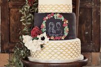 a large wedding cake with white and gold scallop tiers, with a chalkboard one, with portraits and sugar blooms in red and white