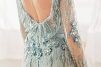 a light blue sheath fully embellished wedding dress with a low back and long sleeves is a very refined and chic option