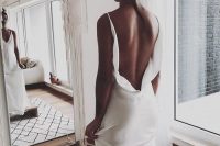 a minimalist plain sheath wedding dress with a low flowy back on straps and a train is pure perfection