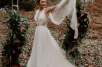 a modern A-line wedding gown with sheer inserts, embellishments and a capelet attached to the dress