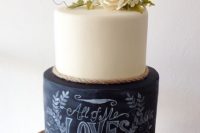 a modern wedding cake wiht a white and a chalkboard tier, with rope and neutral blooms on top plus chalking is amazing