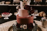 a moody vintage wedding cake in pink, burgundu and black, with floral patterns and lots of sugar blooms