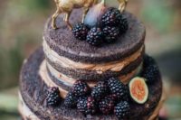 a naked chocolate wedding cake with blackberries, figs and gilded deer toppers for a woodland wedding